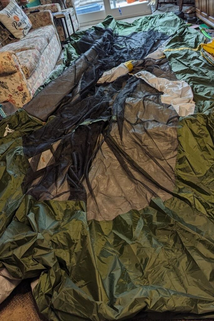 a large tent spread out inside the house needs repair