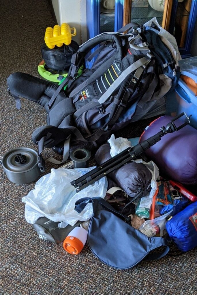 a pile of camping gear on the floor after a hike needs repair
