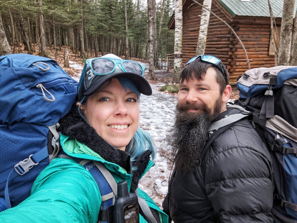 A man and woman with Backpacks on at Harlow Lake cabin in Upper Michigan