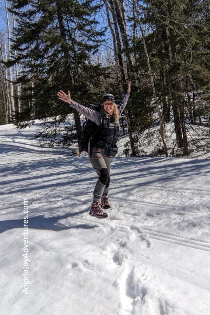 Happy Girl Jumping while Winter hiking in Upper Michigan